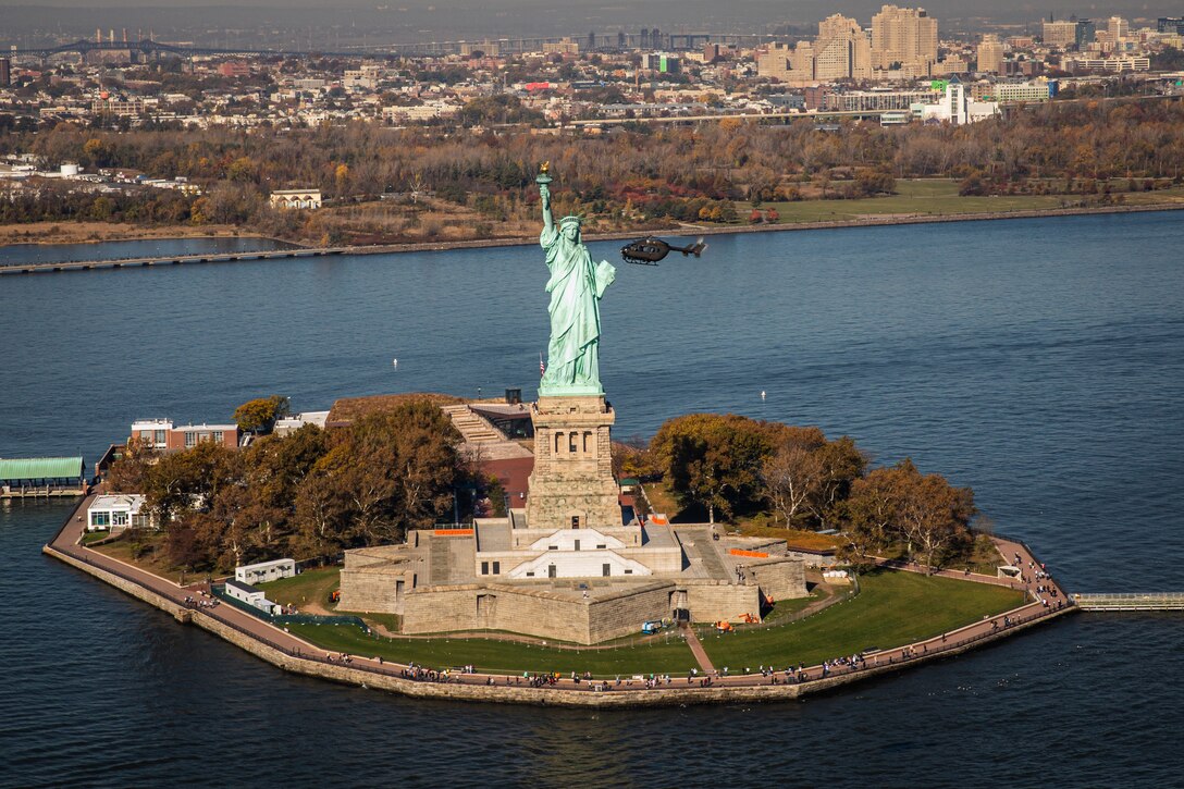 A helicopter flies around the Statue of Liberty.