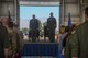 Pictured above are two Airmen standing at attention on a stage during a ceremony.