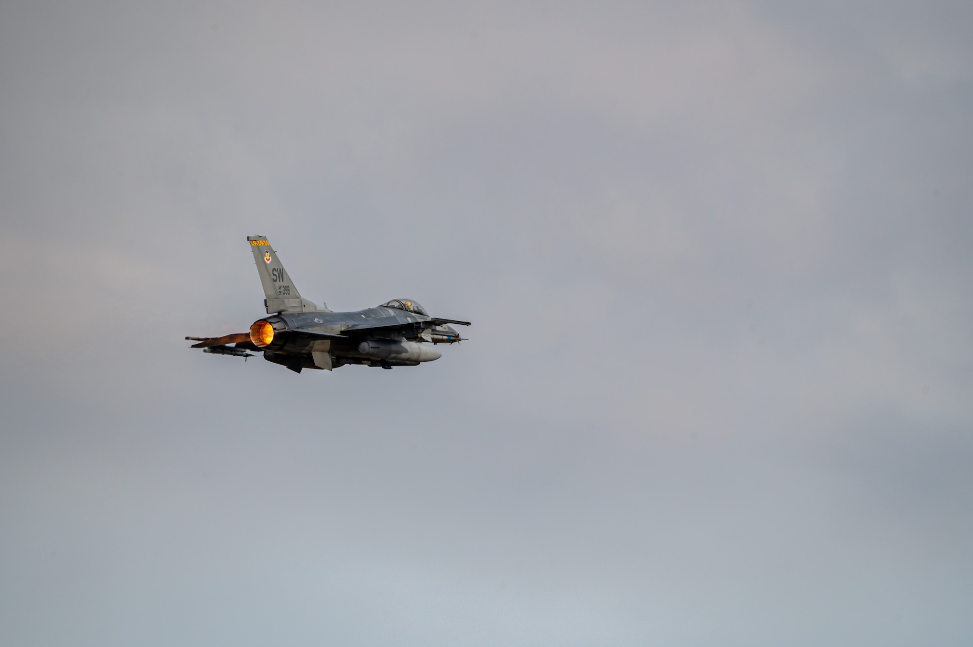 A pilot performing F-16 preflight checks.