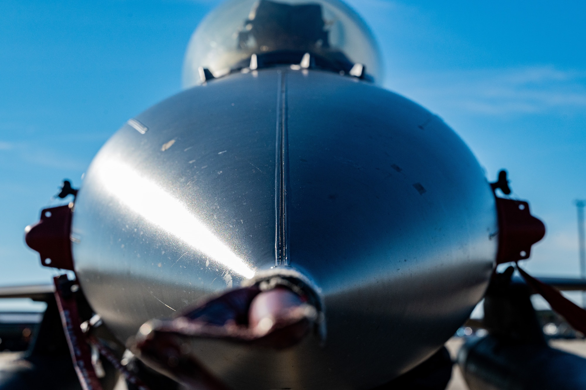 A pilot performing F-16 preflight checks.