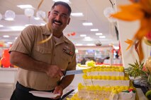 A U.S. Navy Corpsman cuts into a Marine Corps birthday cake at Anderson Chow Hall, Marine Corps Base Hawaii, Nov. 10, 2021. Employees at the Anderson Chow Hall held a birthday lunch celebrating the 246th U.S. Marine Corps Birthday. (U.S. Marine Corps photo by Lance Cpl. Christian Tofteroo)