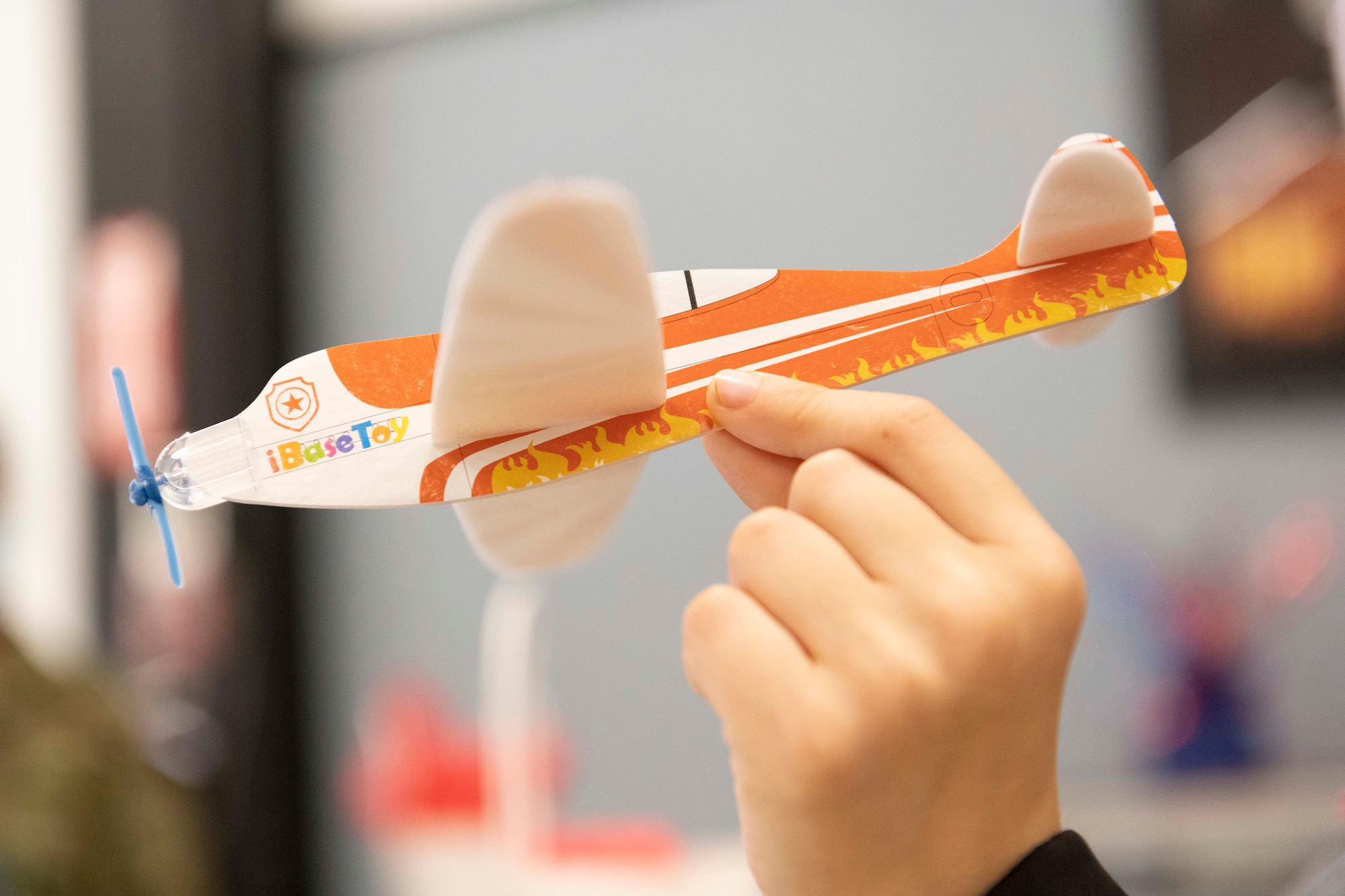 A hand holds a model airplane in the air