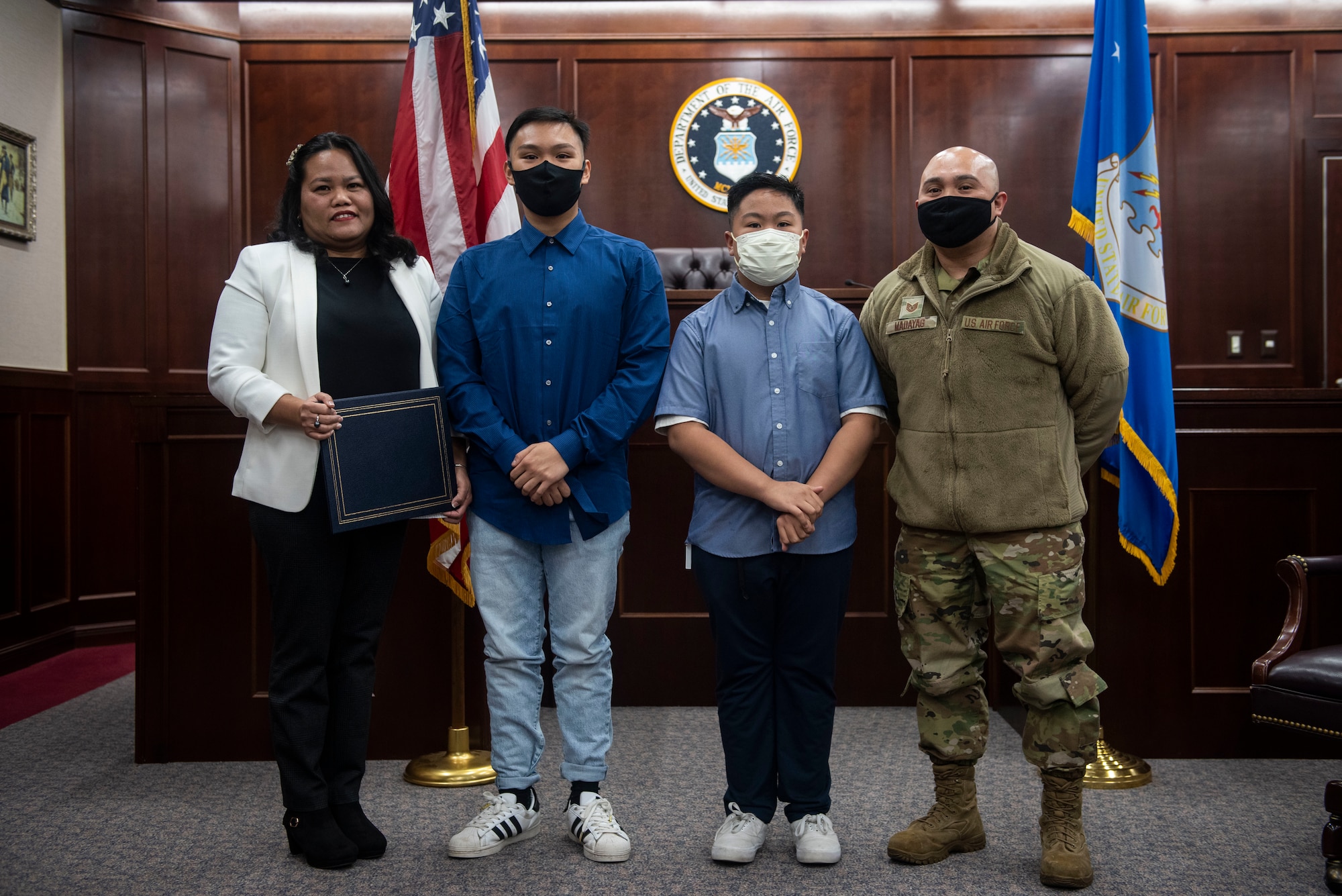 Four family members pose for a photo in a court room.