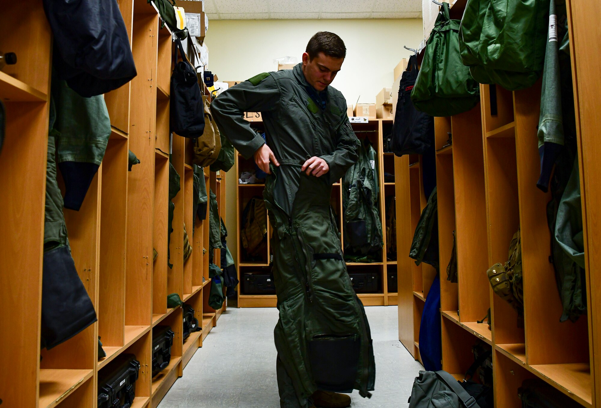 First Lt. Craig Freeh, 35th Fighter Squadron F-16 Fighting Falcon pilot, dons on flight equipment at Kunsan Air Base, Republic of Korea, Nov. 3, 2021. The 8th Fighter Wing pilots depend on Aircrew Flight Equipment Airmen to have attention to detail when handling survival kits, parachutes, maintaining oxygen masks and flight helmets that can mean the difference between life and death. (U.S. Air Force photo by Staff Sgt. Jesenia Landaverde)