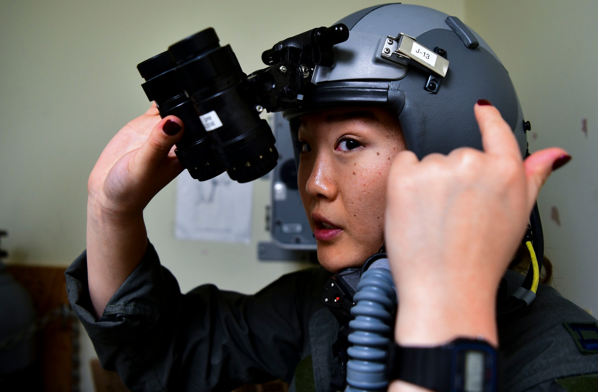 Captain (Doctor) Lisa Choe, 80th Fighter Squadron flight doctor, tests HGU 55-P flight helmet for night vision at Kunsan Air Base, Republic of Korea, Nov. 3, 2021. The 8th Fighter Wing pilots depend on Aircrew Flight Equipment Airmen to have attention to detail when handling survival kits, parachutes, maintaining oxygen masks and flight helmets that can mean the difference between life and death. (U.S. Air Force photo by Staff Sgt. Jesenia Landaverde)