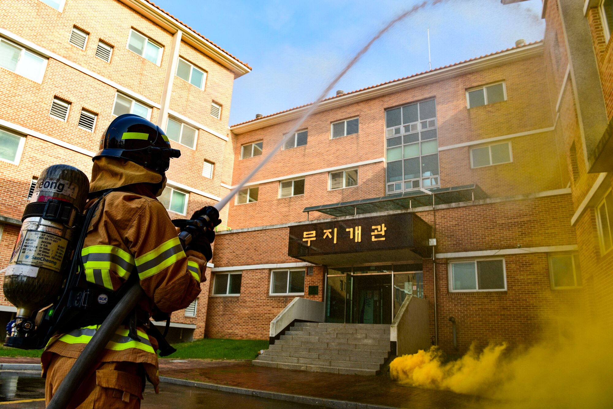 Republic of Korea Air Force Senior Airman Moon Hakinn, 38th Civil Engineer Squadron firefighter, hoses down simulated fire at Kunsan Air Base, R.O.K., Nov. 4, 2021. Both 8th Fighter Wing and 38th Fighter Group firefighters were tested in their ability to respond quickly to a simulated structural fire on base. (U.S. Air Force photo by Staff Sgt. Jesenia Landaverde)