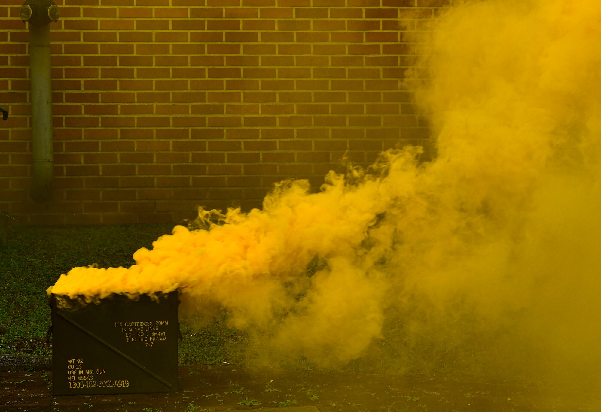 Yellow smoke fills the air signaling a simulated structure fire at Kunsan Air Base, Republic of Korea, Nov. 4, 2021. Both 8th Fighter Wing and 38th Fighter Group firefighters were tested in their ability to respond quickly to a simulated structural fire on base. (U.S. Air Force photo by Staff Sgt. Jesenia Landaverde)