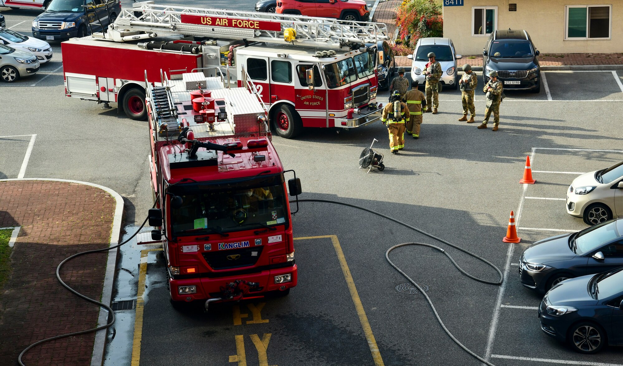 Airmen from the 8th Civil Engineer Squadron and 38th CES firefighter rush to scene during a simulated structure fire at Kunsan Air Base, Republic of Korea, Nov. 4, 2021. Both 8th Fighter Wing and 38th Fighter Group firefighters were tested in their ability to respond quickly to a simulated structural fire on base. (U.S. Air Force photo by Staff Sgt. Jesenia Landaverde)