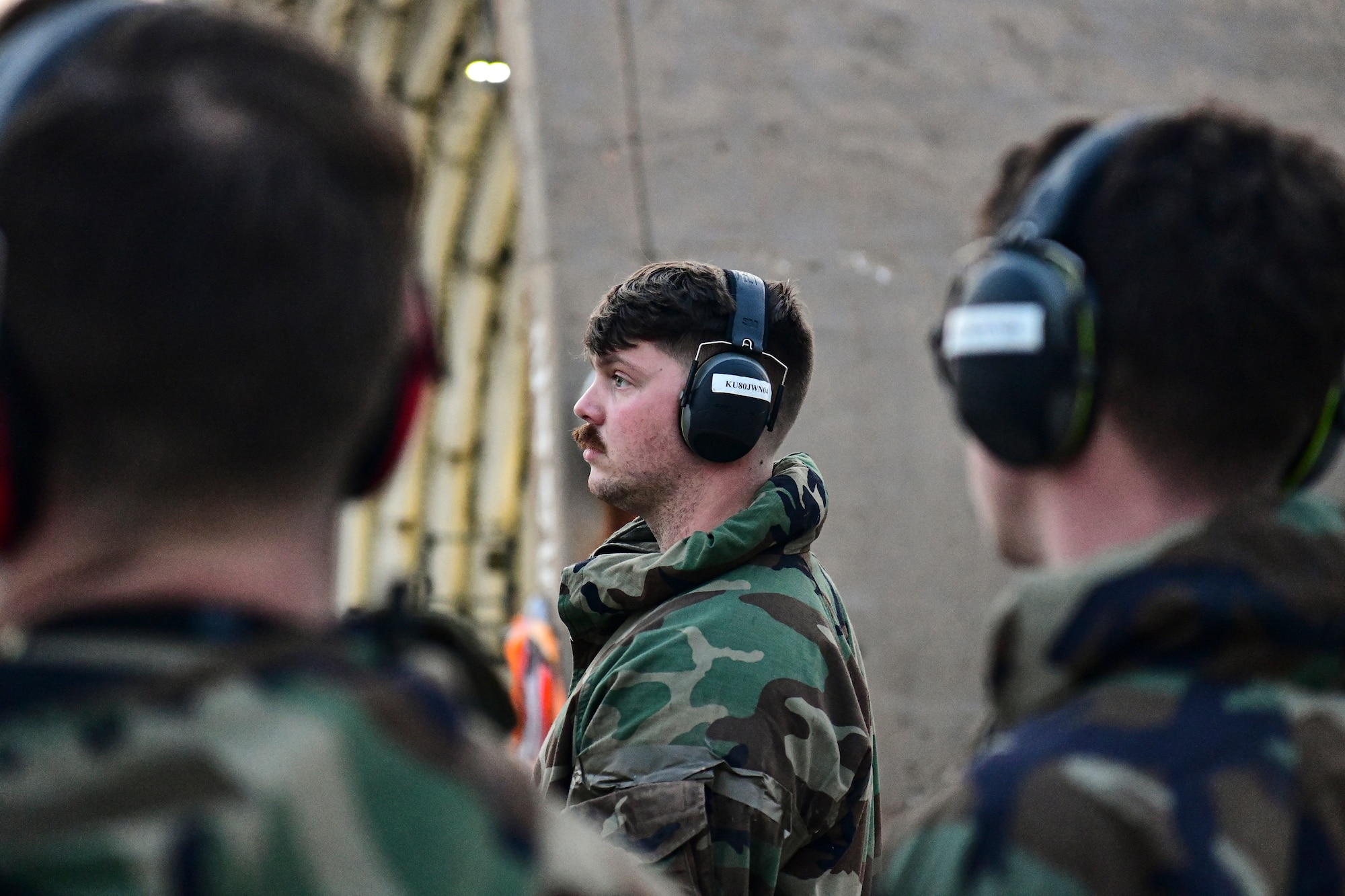 An Airman waits for a jet to taxi.