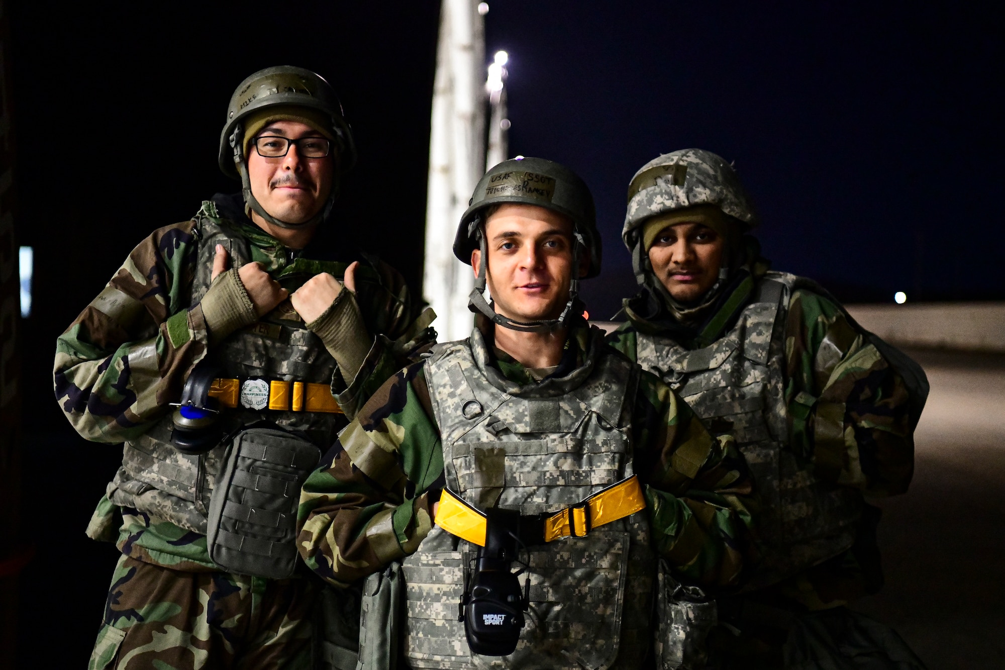 Airmen stand together in a hangar.