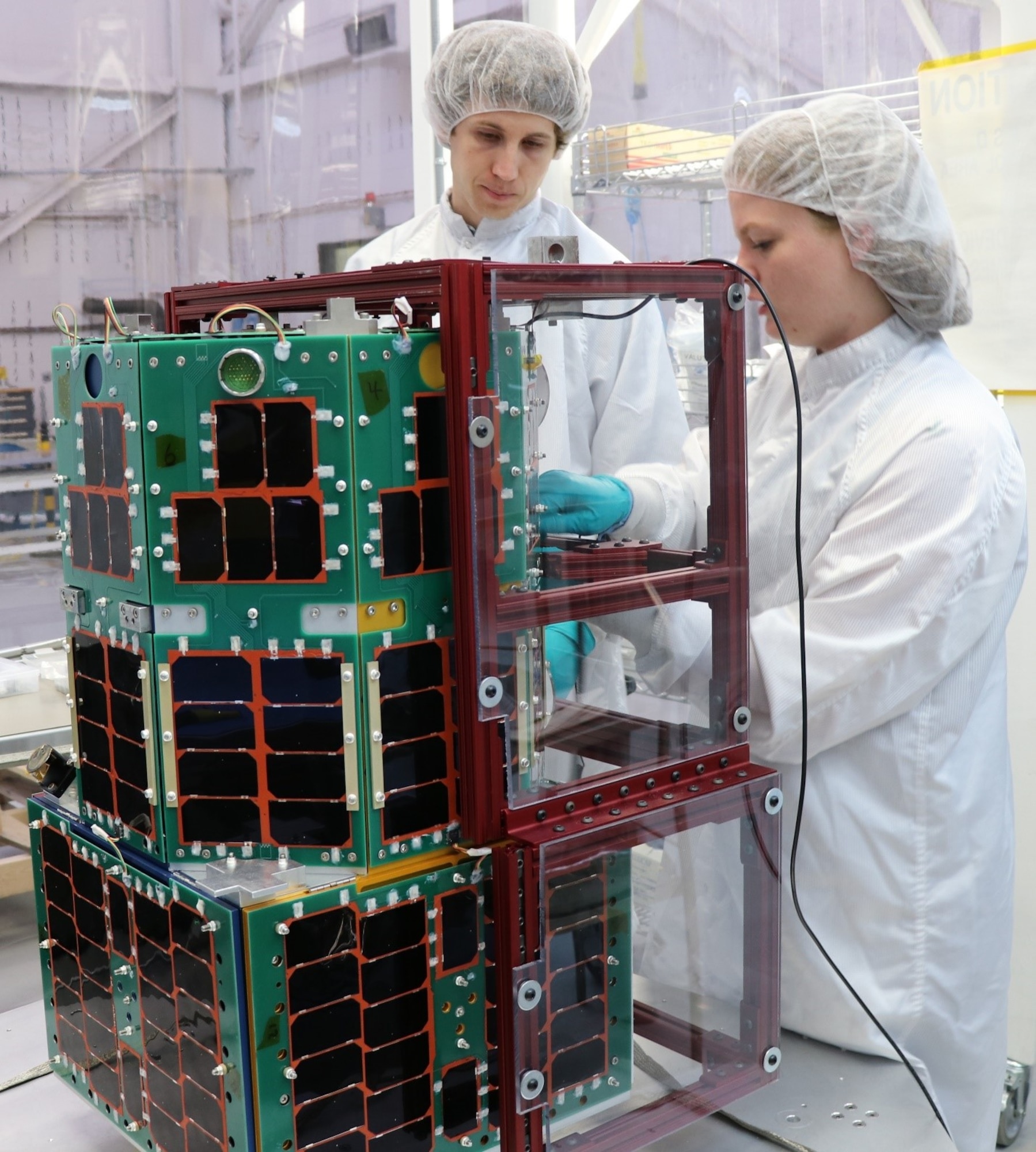 Two University Nanosatellite Program students assemble the Oculus-ASR satellite. (AFRL Photo)
