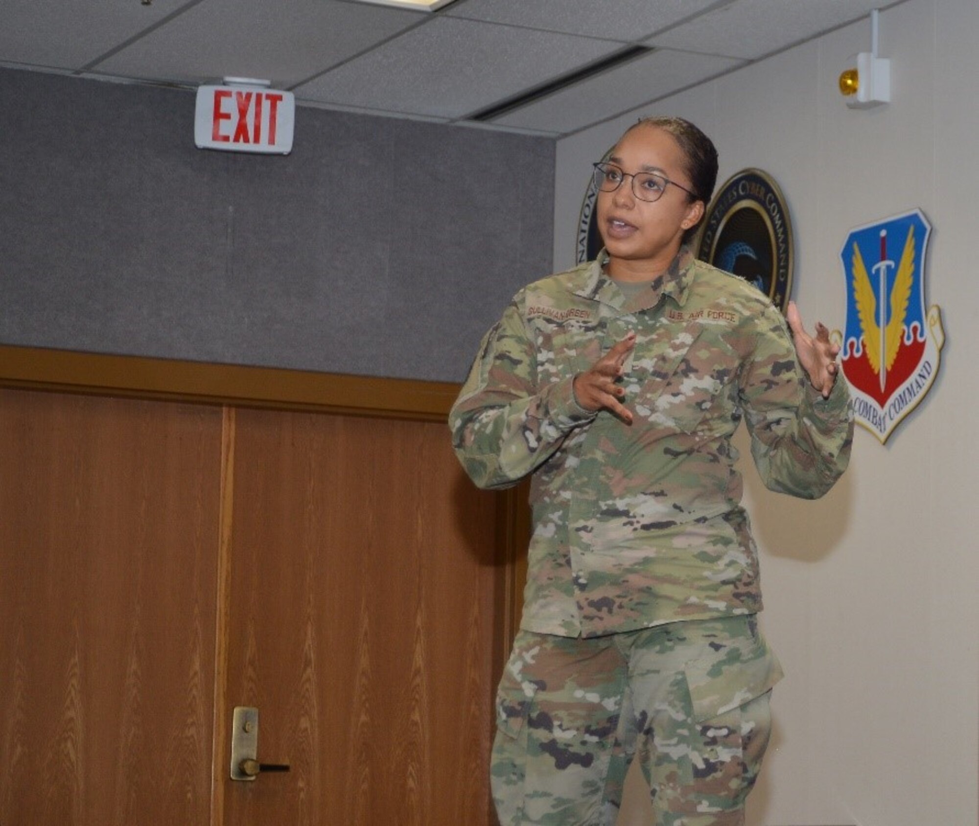 Airman in uniform speaks to a group.