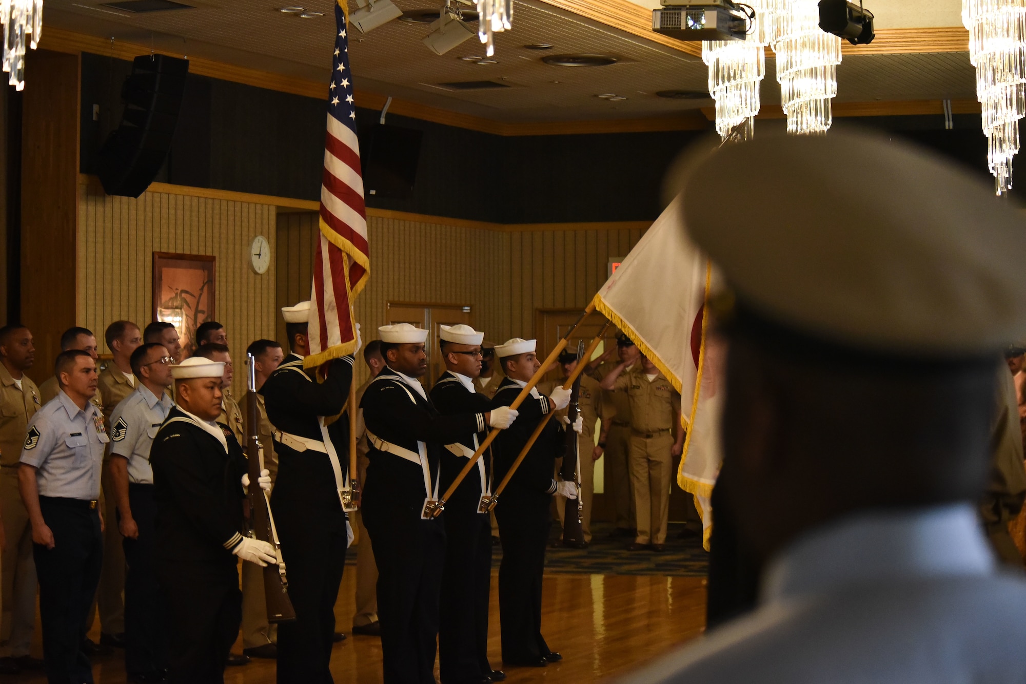 The U.S. Navy honor guard hold flags during the national anthems