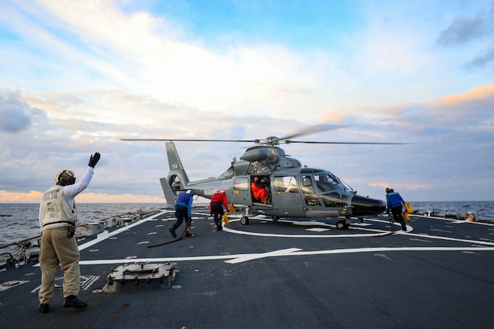 Sailors assigned to the Arleigh Burke-class guided-missile destroyer USS Porter (DDG 78) assist with chocks and chains as part of flight operations with the French Navy during Exercise Polaris on Patrol 10, Nov. 23, 2021.