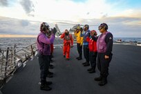 Sailors assigned to the Arleigh Burke-class guided-missile destroyer USS Porter (DDG 78) act as side boys and salute Rear Adm. Christophe Cluzel, assigned to the French Navy, as part of flight operations with the French Navy during Exercise Polaris on Patrol 10, Nov. 23, 2021.