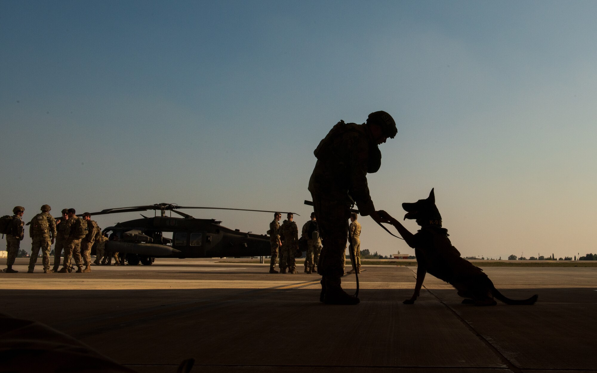 A military working dog handler and his dog practice waits for a joint training exercise to start