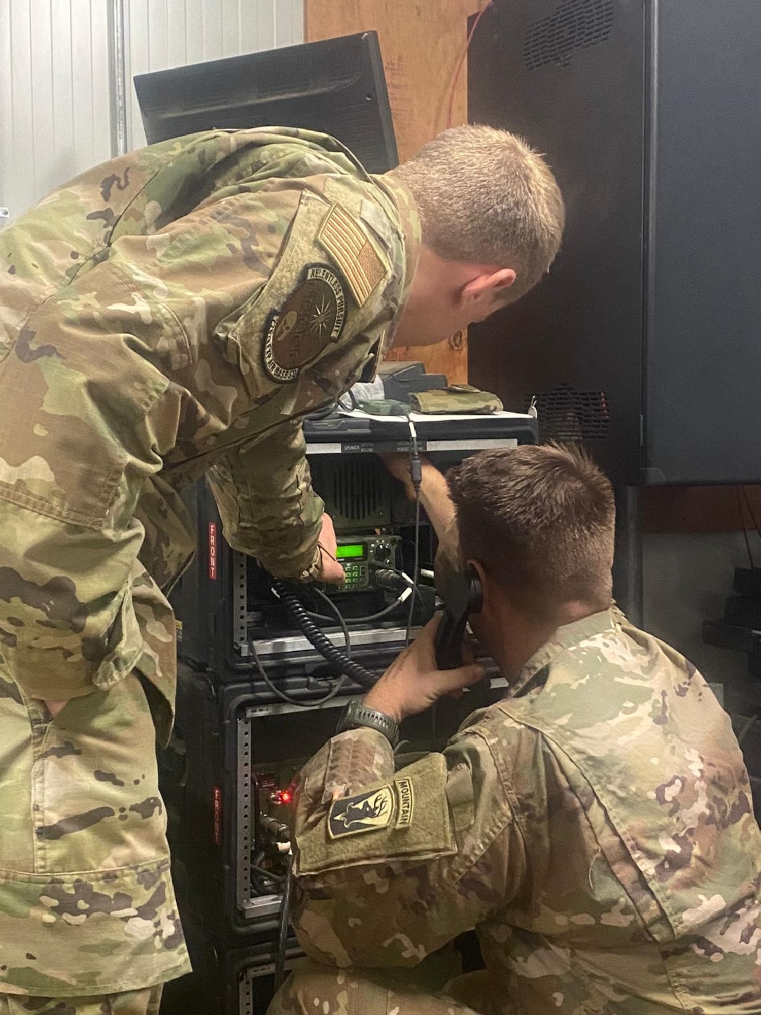 U.S. Air Force Tech. Sgt. Stephen Paice, 776th Expeditionary Air Base Squadron radio frequency NCO in charge, assist U.S. Army Sergeant Taylor Post, Task Force Iron Grey Battle Company lead radio technician, with manipulating radio waves while talking to someone at a different station during Noble Skywave Global High Frequency (HF) competition at Chabelley Airfield, Djibouti, Oct 27, 2021. Noble Skywave is a 60-hour event, where teams have to demonstrate the ability to make HF radio transmission around the world. (U.S. Air Force Courtesy Photo)