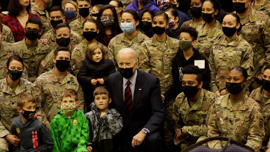 President Joe Biden poses with soldiers and their families.