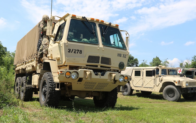 Two military vehicles are parked on a patch of grass.