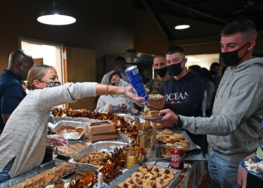 U.S. Air Force Chief Master Sgt. Rebecca Arbona, 17th Training Wing command chief, tops a slice of apple pie with whipped cream during a Thanksgiving event at the Crossroads on Goodfellow Air Force Base, Texas, Nov. 23, 2021. Arbona served each Airman and interacted with them during the event. (U.S. Air Force photo by Senior Airman Michael Bowman)
