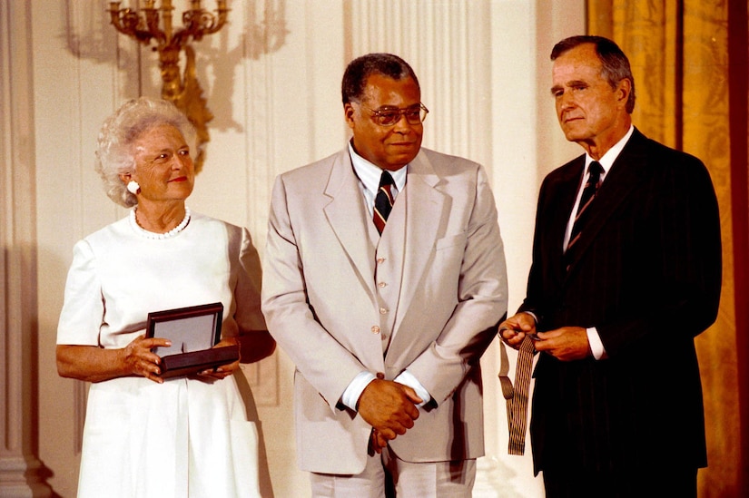 A woman and two men pose for a photo.