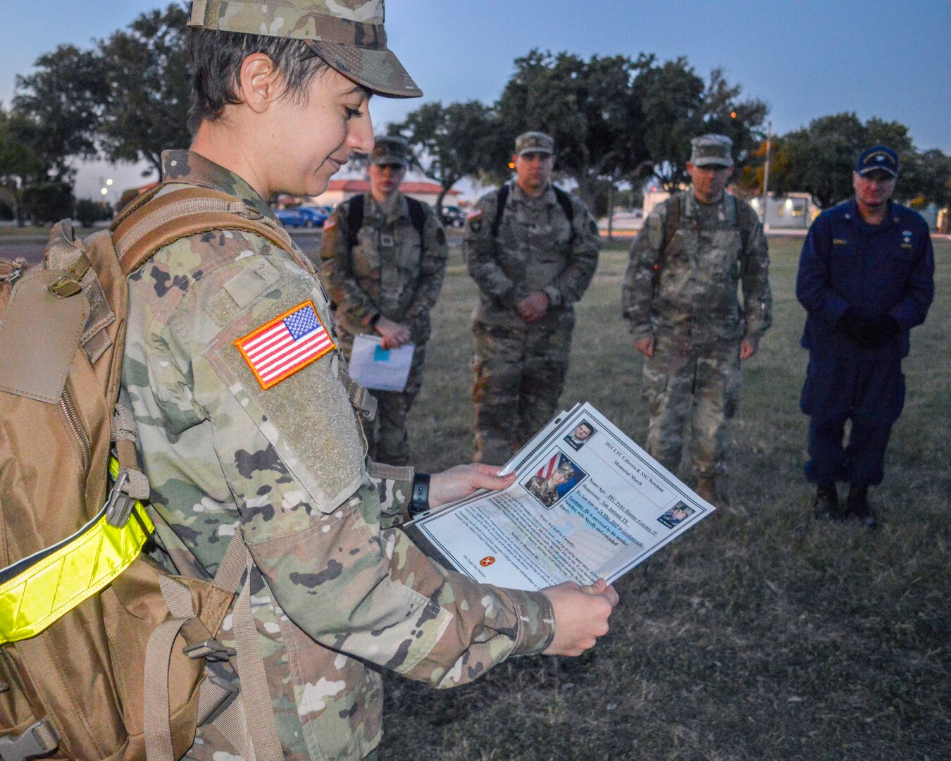 Army Capt. Leanne Bishara, clinical psychology intern, reads the biography of a fallen service member during a memorial march