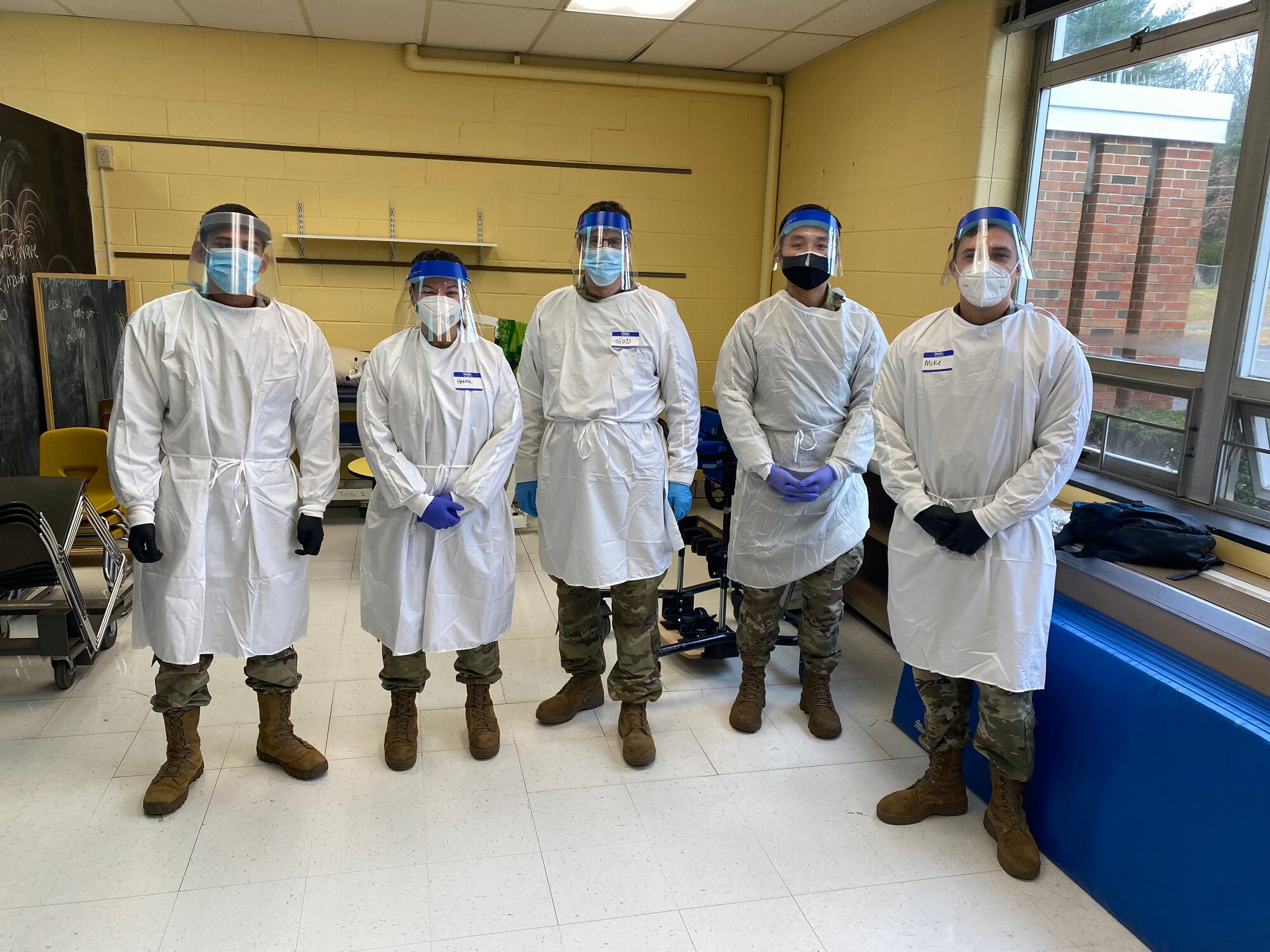 Airmen and Soldiers with the Massachusetts National Guard pose for a photo prior to conducting COVID-19 testing Nov. 18, 2021, in the Northampton, Massachusetts school district. The Massachusetts National Guard was activated in mid-October to augment COVID-19 testing personnel in school districts across the state.(U.S. Air National Guard photo by Staff Sgt. Hanna Smith)
