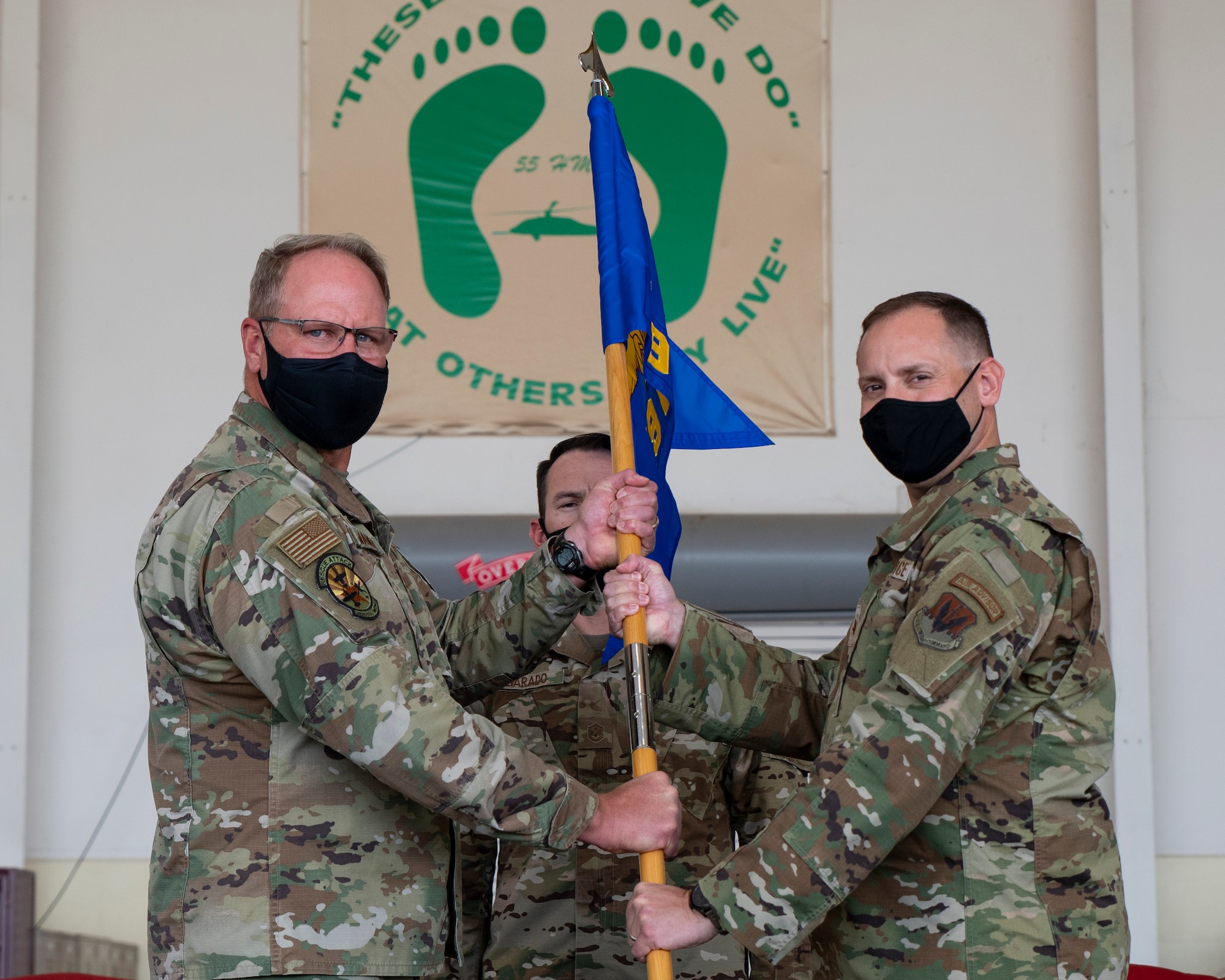 two men hold a guidon.