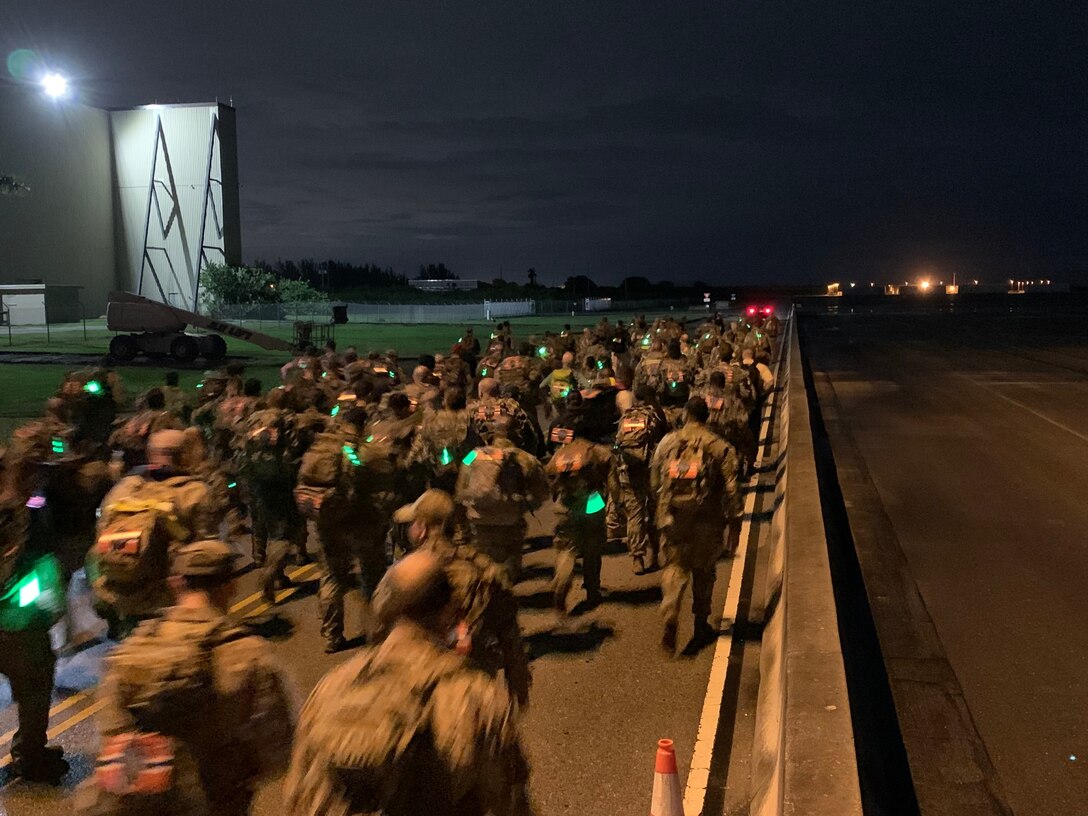 U.S. military members and civilians affiliated with Special Operations Command South, U.S. Southern Command, Coast Guard, Air Force Reserve, Florida National Guard and Army Recruiting Command begin the Norwegian Foot March at Homestead Air Reserve Base, Florida, on Nov. 19, 2021.