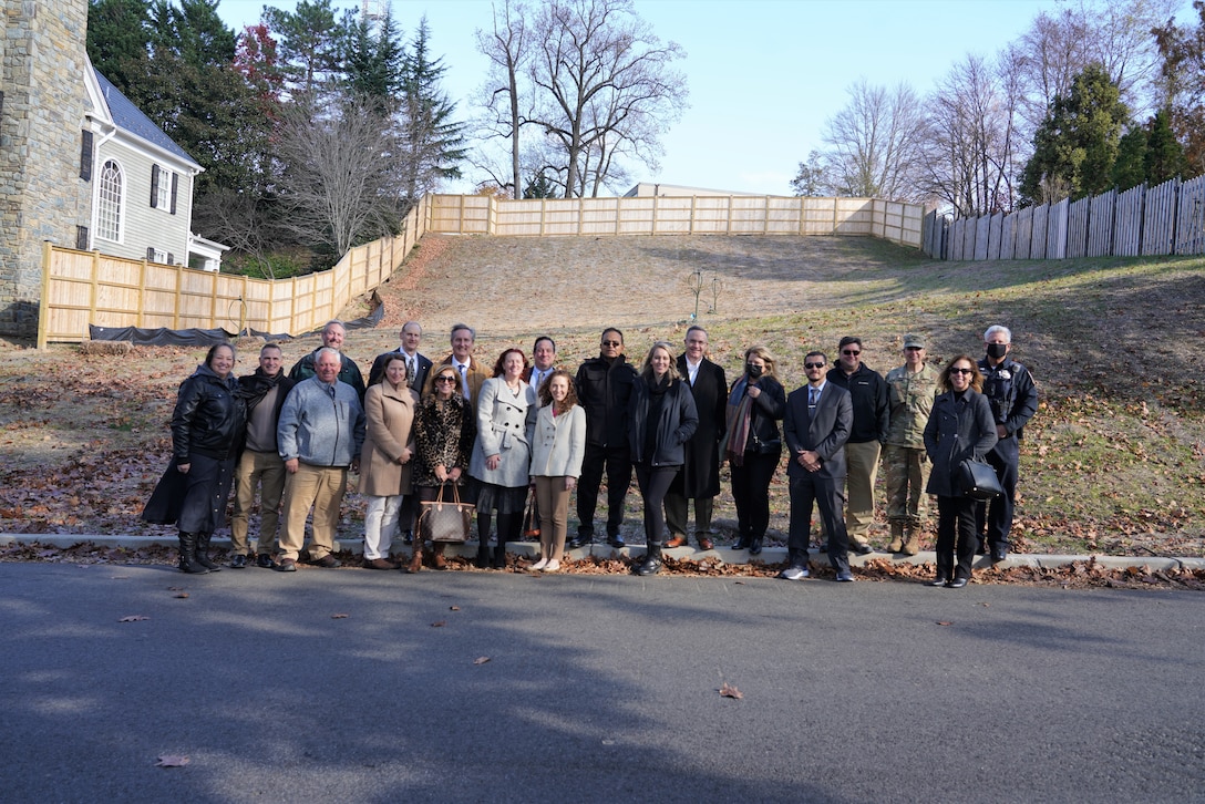 USACE staff, partnering agencies, and contractors stand in front of 4825 Glenbrook Road directly following a ceremony marking the completion of remediation and restoration efforts at the Formerly Used Defense Site, located in Northwest Washington, D.C., Nov. 23, 2021.