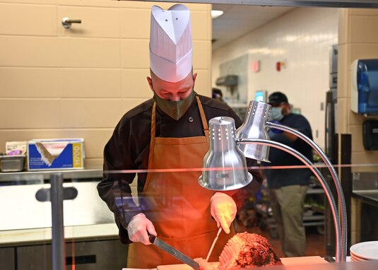 U.S. Air Force Col. Matthew Reilman, 17th Training Wing commander, carves roast beef during Thanksgiving at the Western Winds Dining Facility on Goodfellow Air Force Base, Texas, Nov. 25, 2021. Reilman and other permanent party members of the 17th TRW showed their appreciation for service members in the area. (U.S. Air Force photo by Senior Airman Ethan Sherwood)