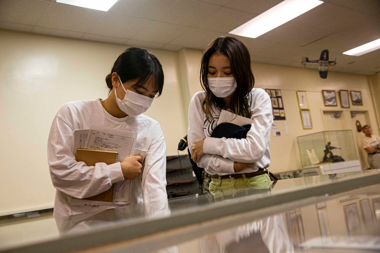 沖縄戦歴史展示会場で沖縄戦の遺品を見学する沖縄国際大学の学生、米海兵隊基地キャンプ・キンザー、2021年11月22日