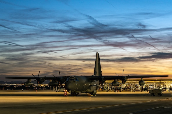 An HC-130J Combat King II sits on the flight line as the sun sets at Nellis Air Force Base