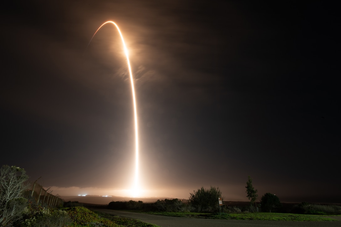 A rocket launches and soars into a dark sky.