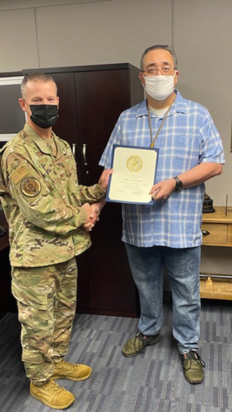 Col. Jason Kalin poses with Darren McMahon to present him with a certificate marking his 35 years of federal service.