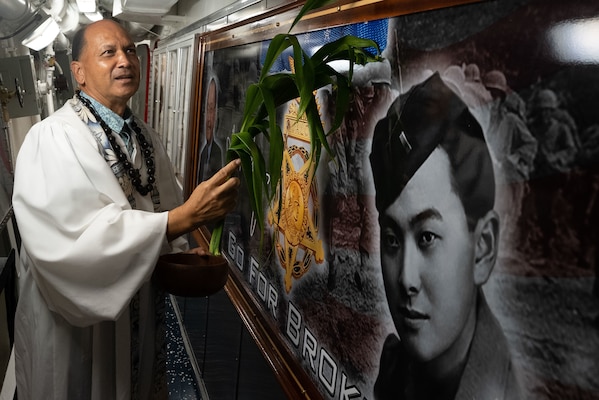 Kordell Kekoa, a Kahu or Hawaiian pastor, performs a Hawaiian blessing on a mural of the ship's namesake, Sen. Daniel K. Inouye, aboard the Navy's newest guided-missile destroyer, the future USS Daniel Inouye (DDG 118).