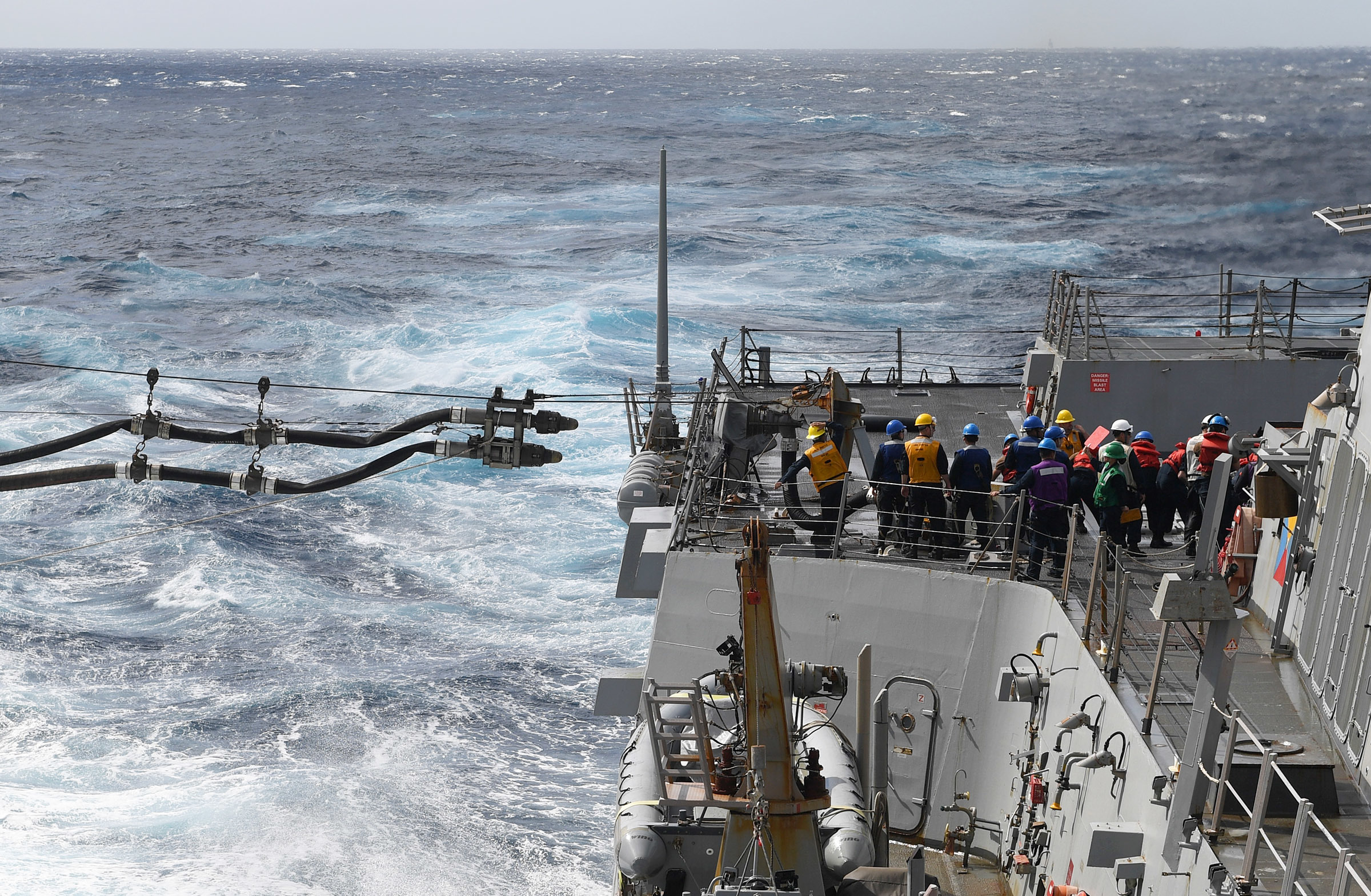 The Arleigh Burke-class guided-missile destroyer USS Chafee (DDG 90) receives a fuel line from the Henry J. Kaiser-class fleet replenishment oiler USNS Big Horn (T-AO 198).