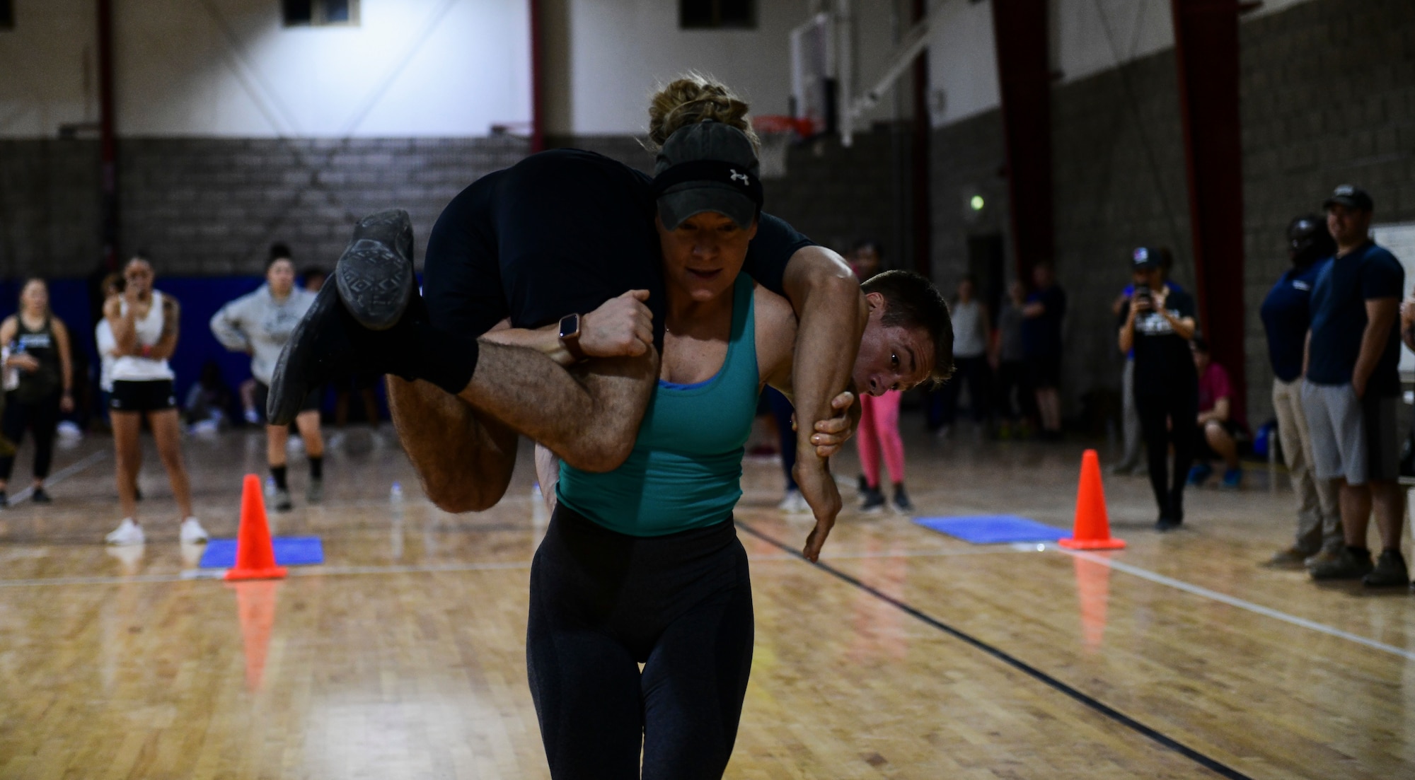 Airman carries wingman during fitness event.