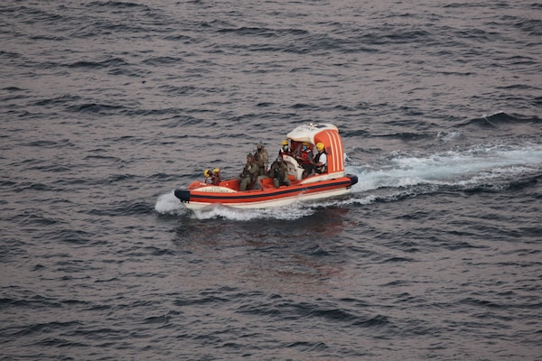 Personnel from dry cargo ship USNS Charles Drew (T-AKE 10) transport an Iranian mariner Nov. 27 in the Gulf of Oman. Two Iranian mariners requested assistance after their fishing vessel was adrift at sea for eight days.