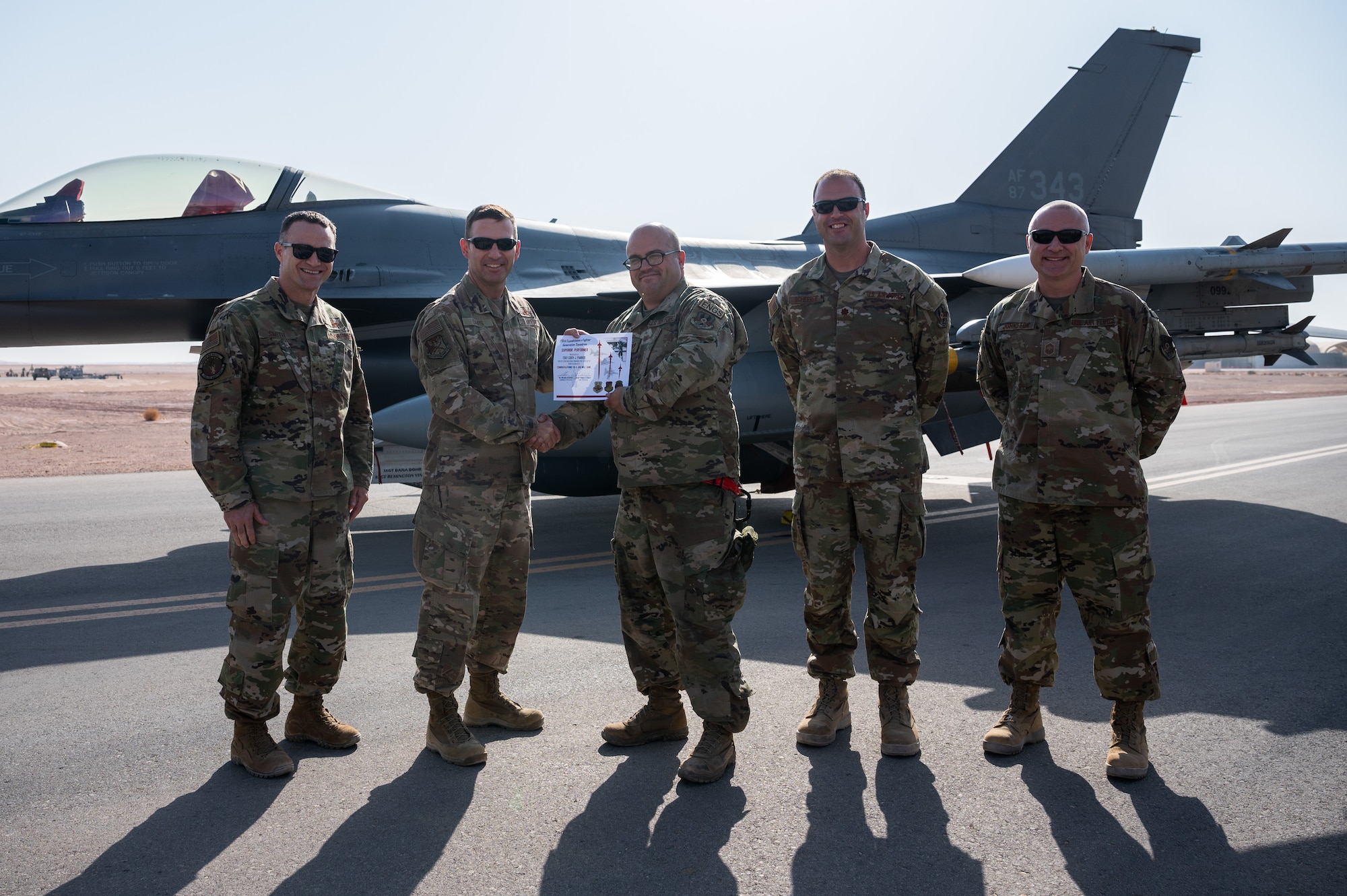 Tech Sgt. Cody J. Parrot, 176th Expeditionary Fighter Squadron aircraft electrical and environmental systems specialist, receives a superior performer certificate from Brig. Gen. Robert Davis, 378th Air Expeditionary Wing commander, at Prince Sultan Air Base, Kingdom of Saudi Arabia, Nov. 23, 2021. Parrot was recognized for his superior performance in Iron Falcon 2021, a bilateral training exercise with Saudi coalition partners. (U.S. Air Force photo by Senior Airman Jacob B. Wrightsman)