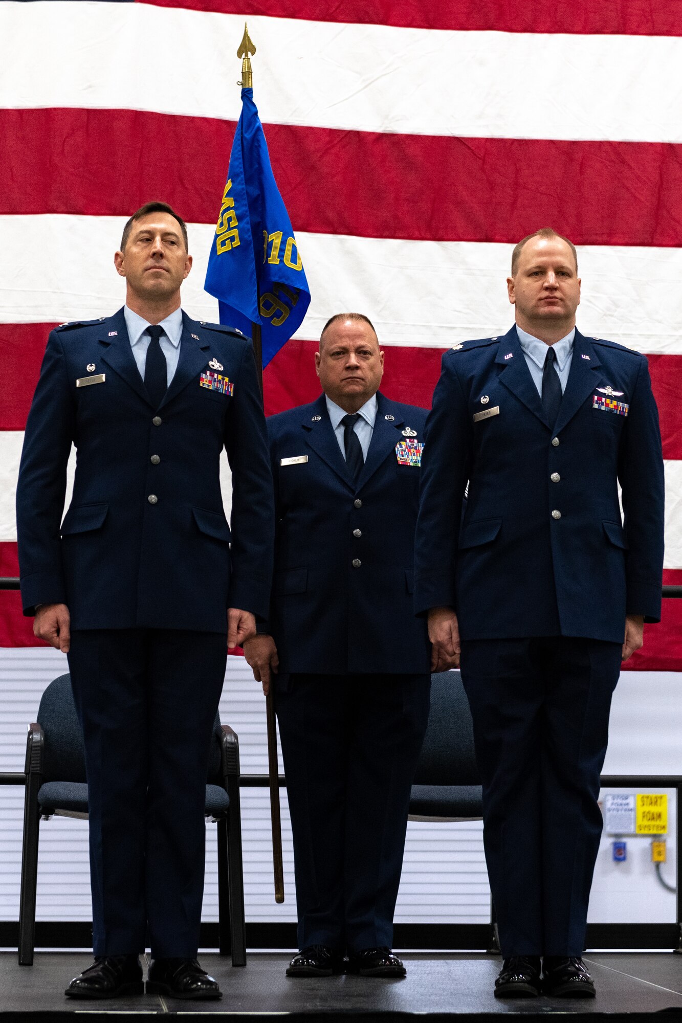 Col. Greg Meyer, commander of the 910th Mission Support Group (right), and Maj. Marc Meyer, the incoming 910th Communications Squadron commander (left), stand at attention seconds before the official passing of the guidon ceremony to mark Marc’s assumption of command, Nov. 6, 2021, at Youngstown Air Reserve Station, Ohio.