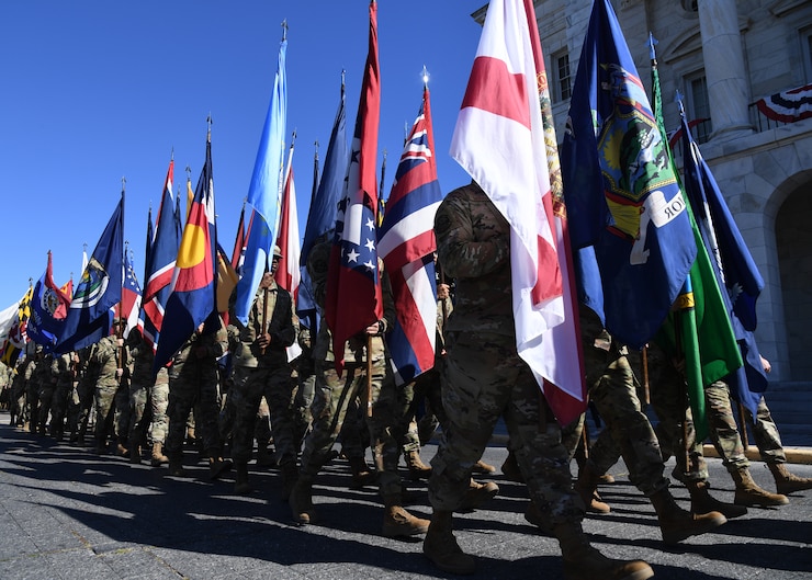 Image of Airmen marching in a parade in Biloxi, MS carrying the 50 state flags