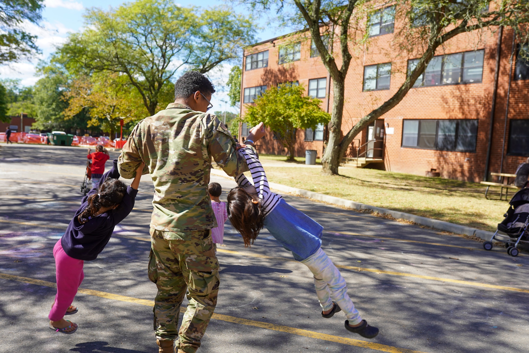 2nd Lt. Oberon-Coultrane Peter plays with Afghan guests in Liberty Village, Joint Base McGuire-Dix-Lakehurst, New Jersey, Sept. 29, 2021. The Department of Defense, through U.S. Northern Command, and in support of the Department of Homeland Security, is providing transportation, temporary housing, medical screening, and general support for at least 50,000 Afghan evacuees at suitable facilities, in permanent or temporary structures, as quickly as possible. This initiative provides Afghan personnel essential support at secure locations outside Afghanistan. (U.S. Air Force photo by 2nd Lt. Taylor Ferry)