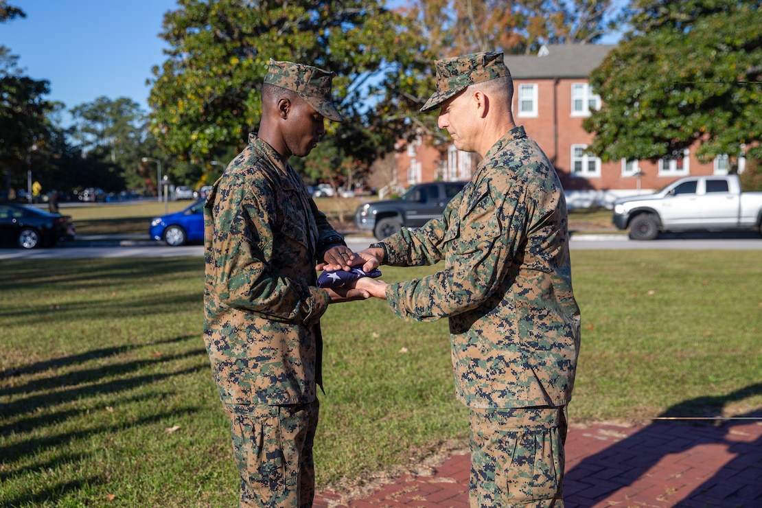 U.S. Marine Corps Cpl. Shevan Salmon, a native of St. Mary, Jamaica, and a heavy equipment operator with Headquarters Battalion, 2d Marine Division (MARDIV), receives an American flag from Maj. Gen. Francis Donovan, commanding general of 2d MARDIV, during a ceremony on Camp Lejeune, N.C., Nov. 16, 2021. Salmon received the flag to commemorate earning American citizenship. (U.S. Marine Corps photo by Lance Cpl. Jennifer E. Reyes)