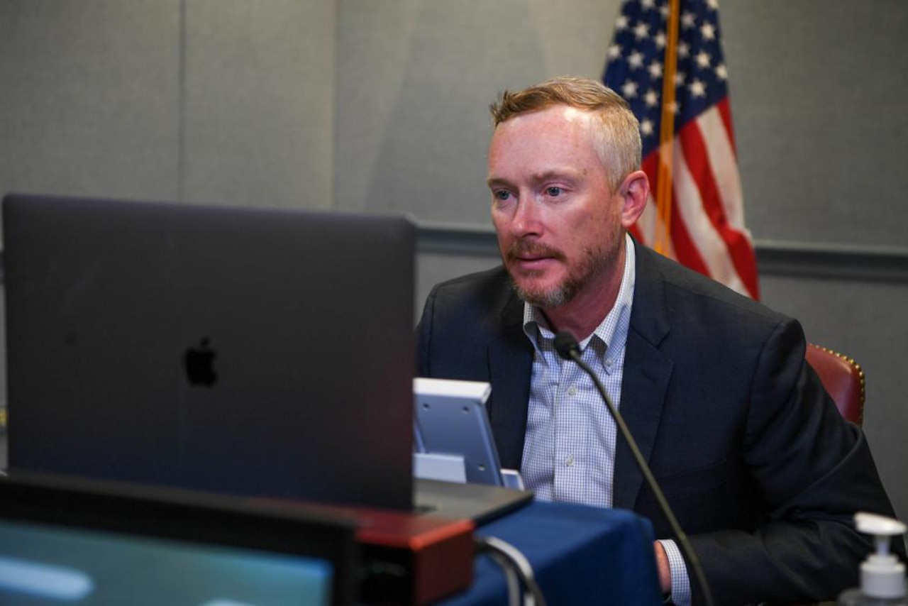 A man looks at a large computer monitor.