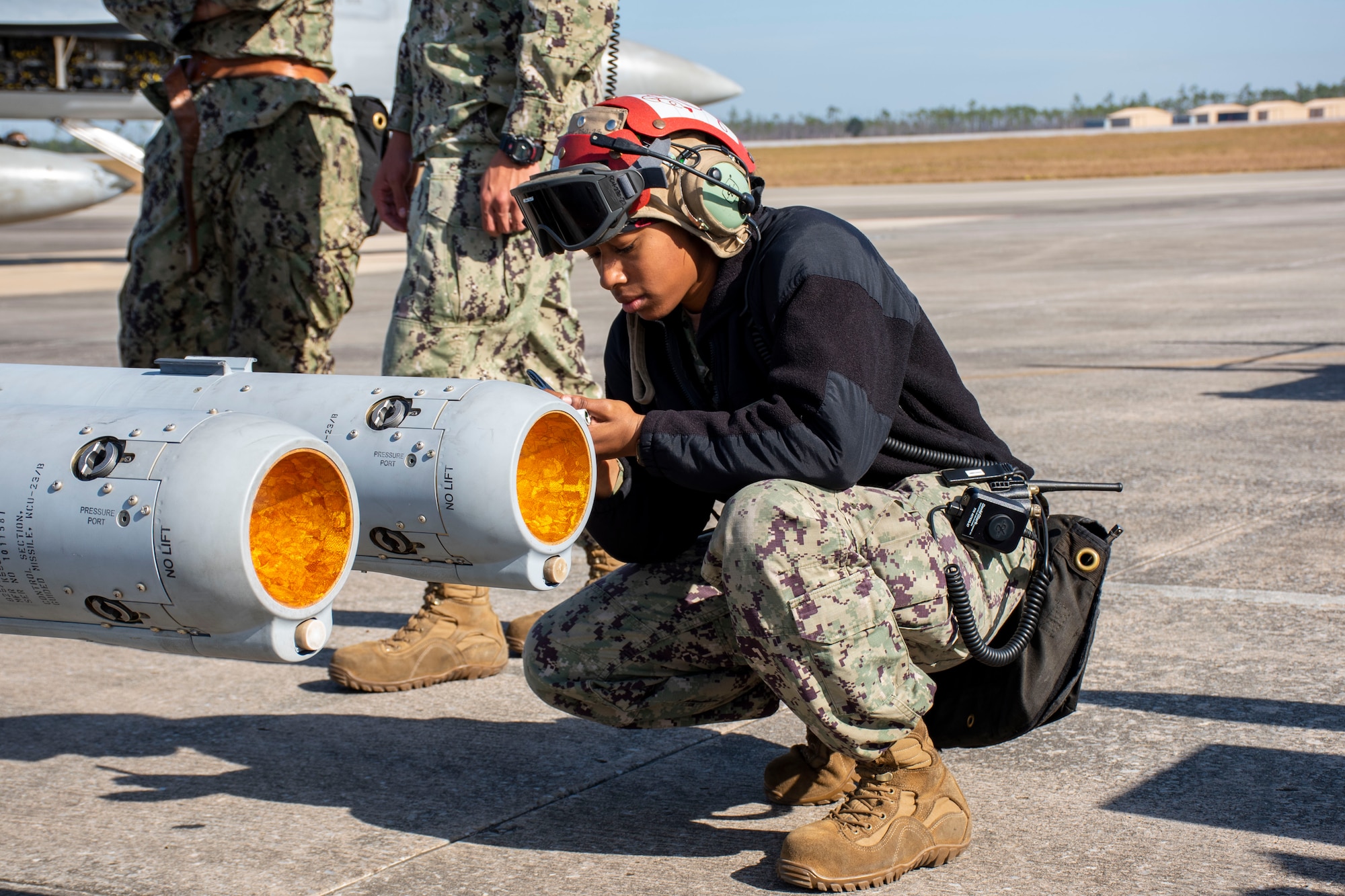 An Aviation Ordnanceman attached to Strike Fighter Squadron 94 inspects two AIM-120 AMRAAMs before a live-fire mission at Tyndall AFB, Fla., Nov. 10, 2021. During WSEP, units across the Department of Defense are evaluated on air-to-air combat capabilities.  (U.S. Air Force photo by 1st Lt Lindsey Heflin)