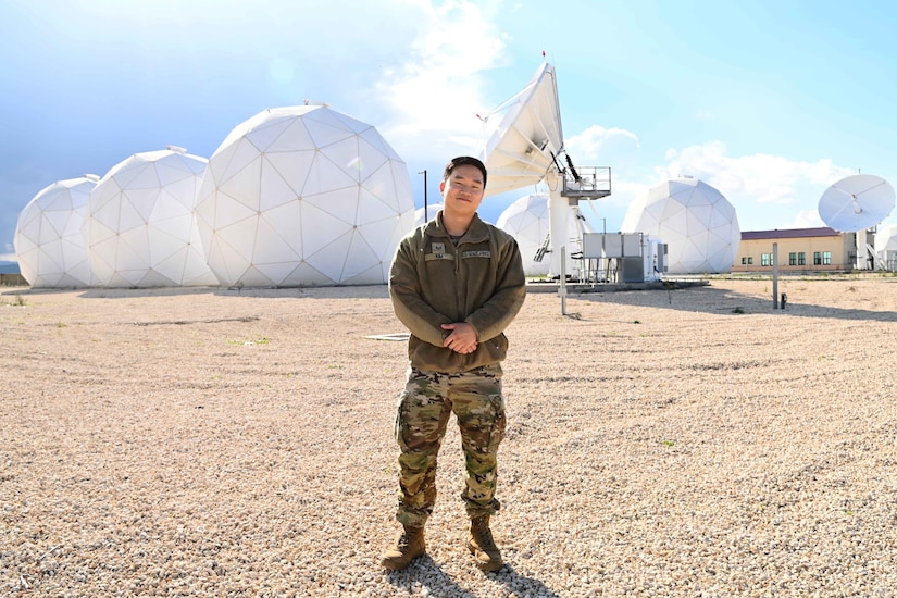 A guardian stands in front of a satellite and dome-type structures.