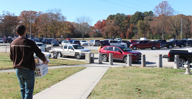 An AEDC team member at Arnold Air Force Base, Tenn., carries baskets of food items donated as part of the Junior Force Council Booster Club's Thanksgiving Food Basket Program.