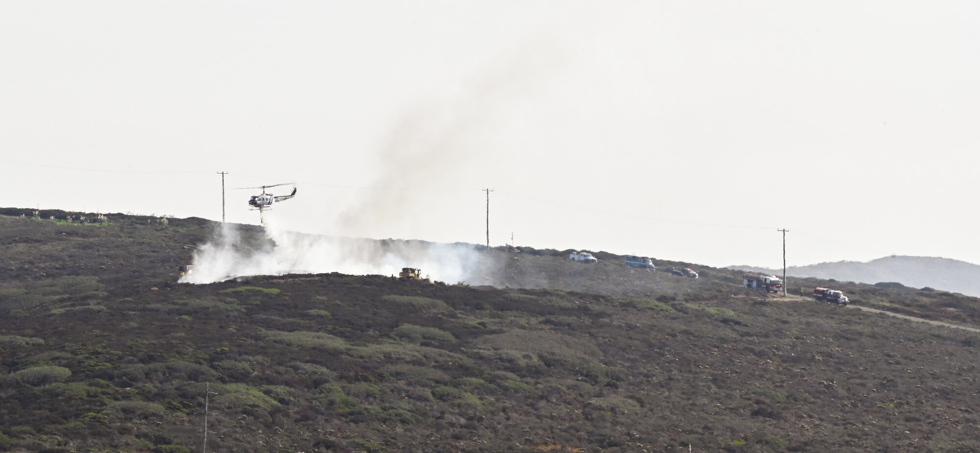 helicopter drops water on fire