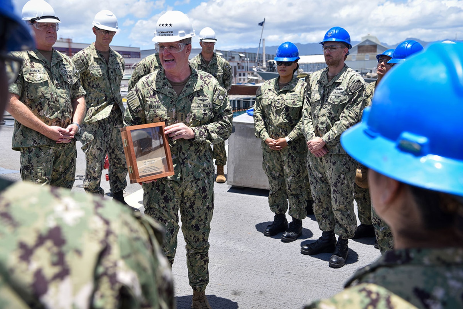 Adm. Samuel Paparo, commander of U.S. Pacific Fleet, presents a relic from the USS Arizona (BB-39) to the crew of the Arleigh Burke-class destroyer USS Chung-Hoon (DDG 93) in remembrance and commemoration of the 80th anniversary of the attack on Pearl Harbor. The relic originates from a section of the superstructure of the Arizona that was removed from the ship when the Arizona Memorial was constructed. The Naval History and Heritage Command authorized the removal of sections of the relics for display and legacy enhancing purposes in 1994.